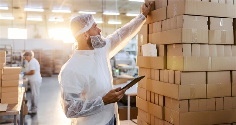 A man is working in a food packaging facility.